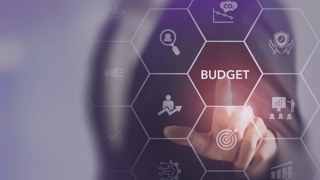 The Power of Budgeting: A Compass for Business Success and Personal Wealth A business professional touching a digital screen with the word "Budget" highlighted among various finance and strategy icons.